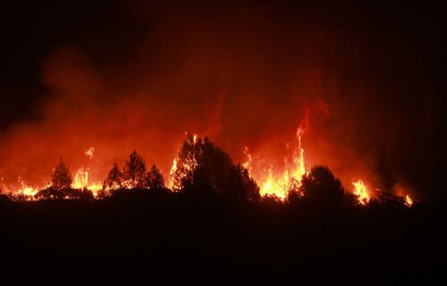 A man waters the roof of his home as the Line Fire burns in the foothills of the San Bernardino Mountains